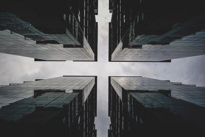 Directly below shot of buildings against sky in city