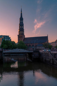 Reflection of buildings in city at sunset