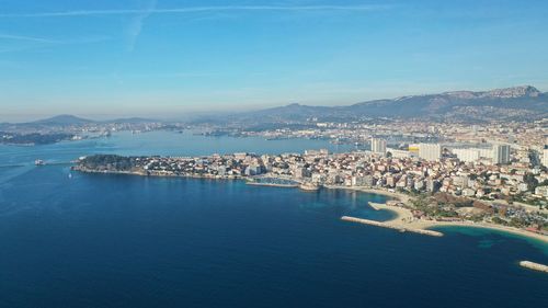 High angle view of city by sea against sky