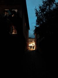 Illuminated alley amidst buildings in city at night