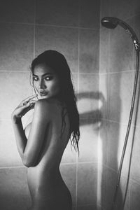 Portrait of seductive woman taking shower in bathtub