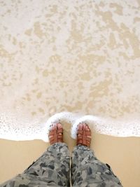 Low section of man standing in sea