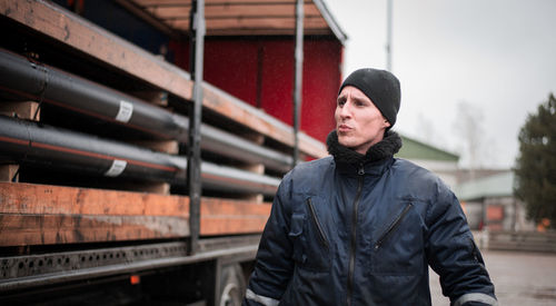 Working man looking away while standing outdoors