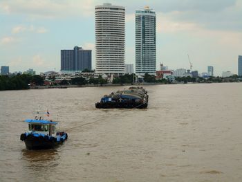 Ship in sea against buildings in city