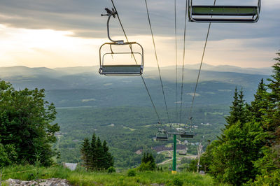 Overhead cable car over mountains against sky