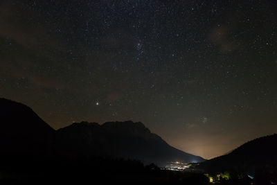 Scenic view of silhouette mountains against sky at night