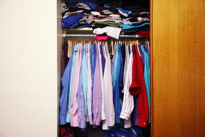 Colorful shirts hanging in closet at home