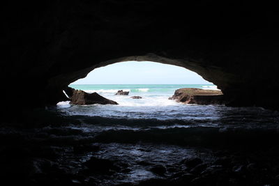 Scenic view of sea seen through cave