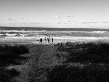 People at beach against sky