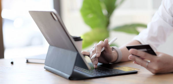 Midsection of man using laptop on table