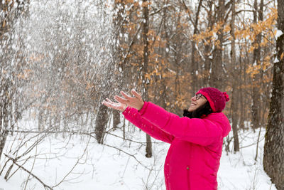 Side view of a woman standing on snow covered field