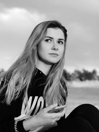 Portrait of a beautiful young woman against sky