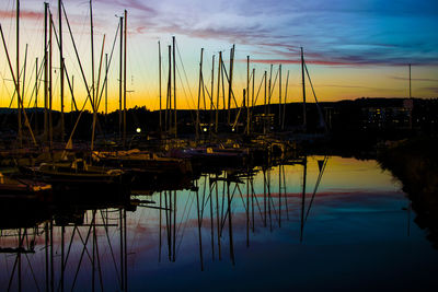 Boats moored in calm sea at sunset