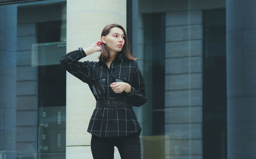 Full length of woman standing against the wall