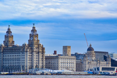 Buildings in city against cloudy sky