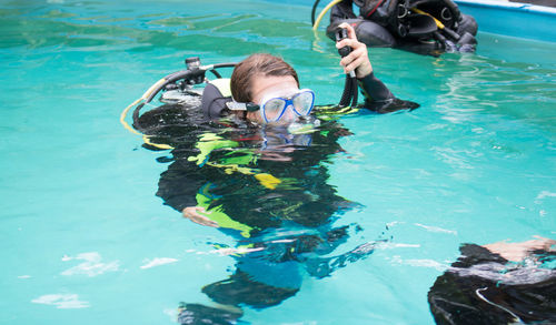 Woman learning underwater swimming with aqualung in pool