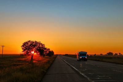 Car on road against sky during sunset