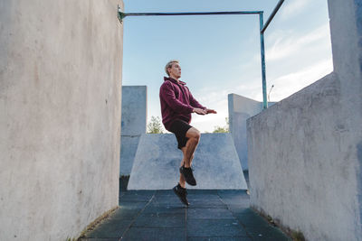 Full length of woman running on wall against building