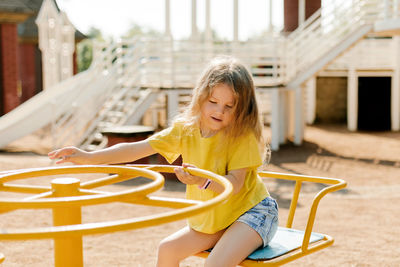 A charming little girl is walking in the park, swinging on a swing. happy childhood, playtime