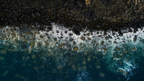 Aerial view of waves splashing on rocks