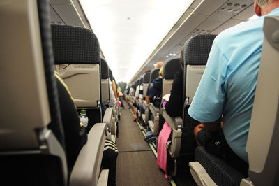 Passengers sitting on vehicle seats in airplane