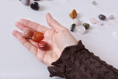 Cropped hand holding gemstones on table