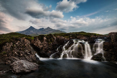 Scenic view of waterfall against sky