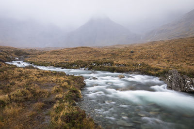 Scenic view of river flowing through mountains