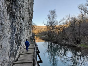 Rear view of man on lake against sky
