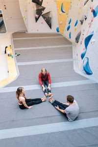 High angle view of coach training male and female students at gym