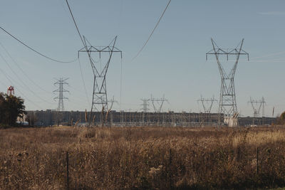 Electricity pylon on field against sky