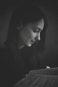 Side view of young woman reading book