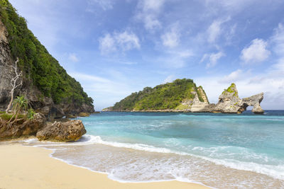 Rock formation on beach against sky