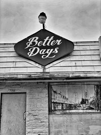 Low angle view of sign on building against sky