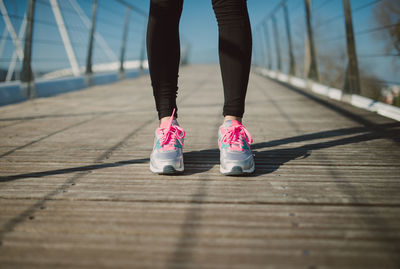 Low section of woman standing on footpath