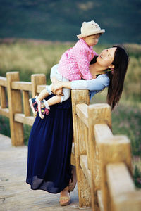 Young woman holding her child outdoors