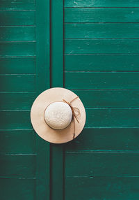 Hat on green door. minimalist, minimalism, entrance.