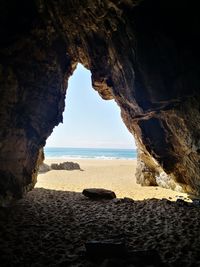 Scenic view of sea seen through cave i. ireland