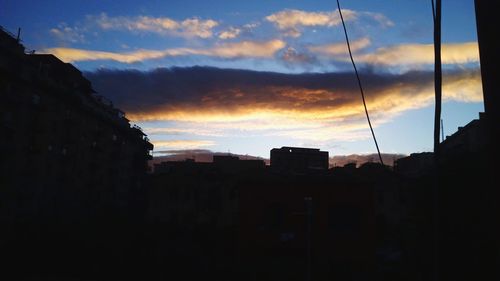 Silhouette buildings against sky during sunset