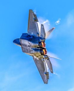 Low angle view of airplane flying against blue sky