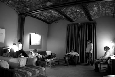 Men relaxing in illuminated room at hotel