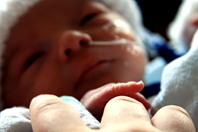 Focus on newborn holding mom's finger. 