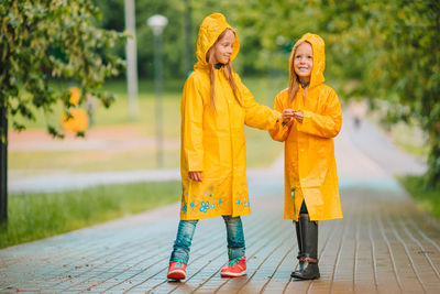 Rear view of women standing on footpath