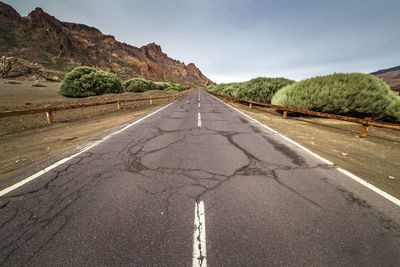 Road by mountain against sky