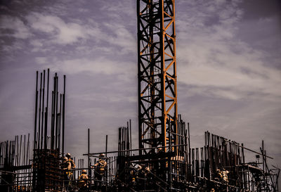 Low angle view of crane against sky at sunset