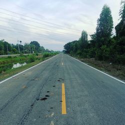 Road amidst trees against sky