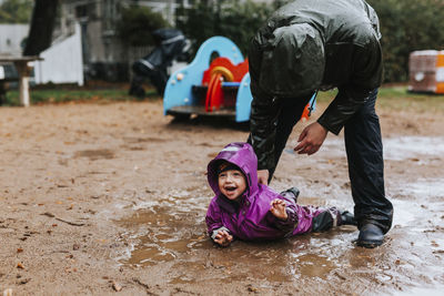 Toddler girl lying in puddle