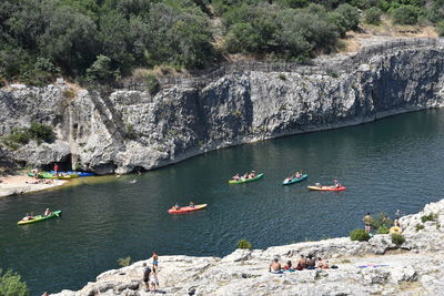 High angle view of people on rocks by lake