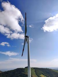 Low angle view of windmill on land against sky