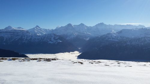 Scenic view of snowcapped mountains against clear blue sky